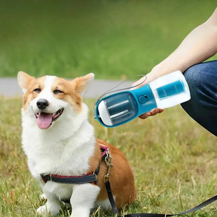 3-in-1 portable pet water bottle being held beside a happy corgi outdoors.